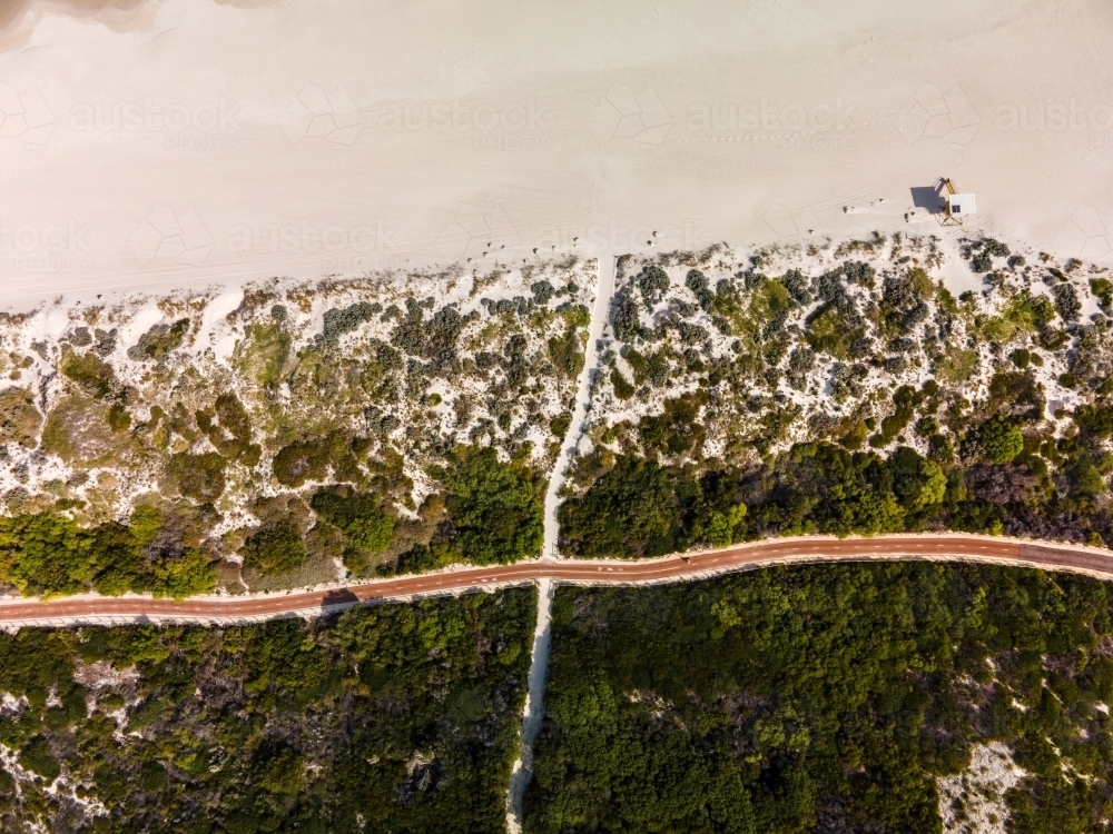 vertical shot of Summers in Perth with white sand, green bushes. and a road - Australian Stock Image