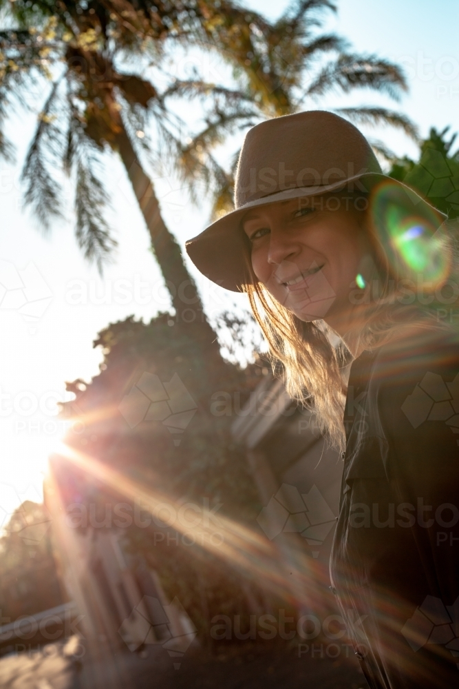 vertical shot of woman with sunlight and trees in the background - Australian Stock Image