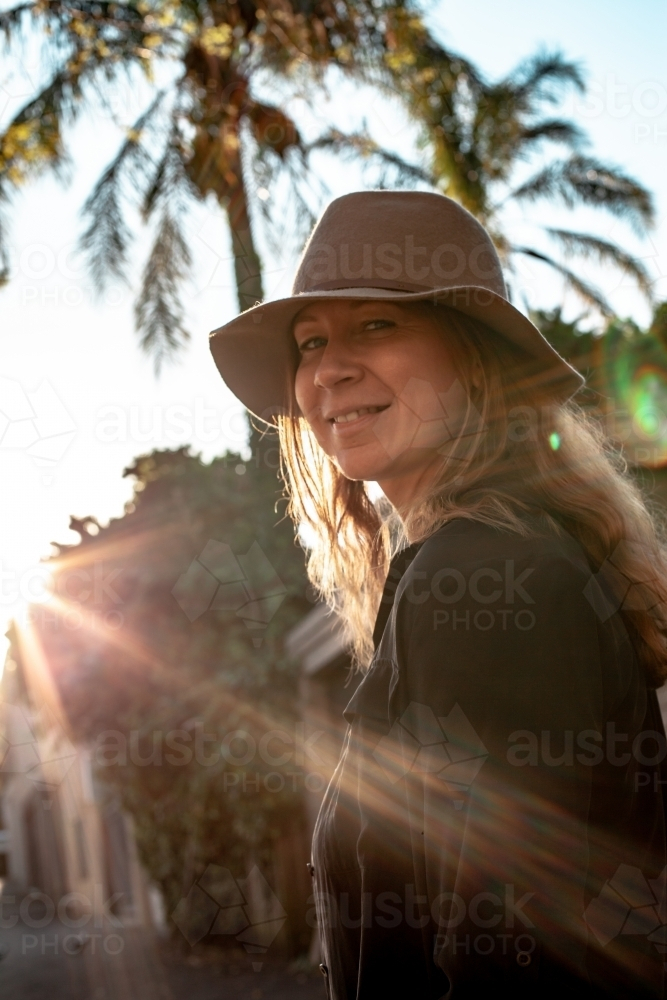 vertical shot of woman with sunlight and trees in the background - Australian Stock Image