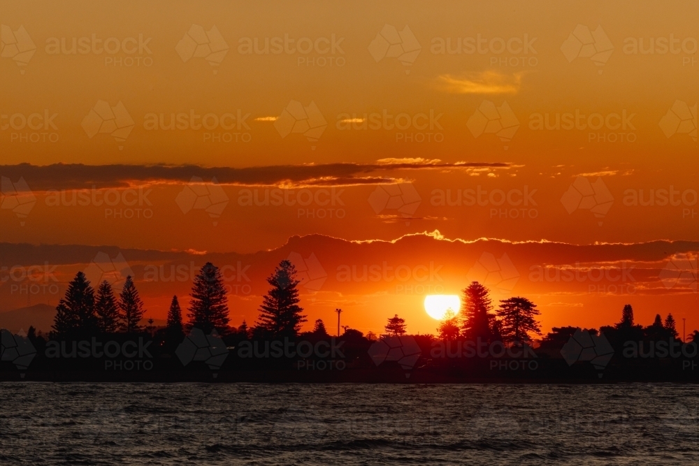 Vibrant orange sunset over Stockton NSW - Australian Stock Image