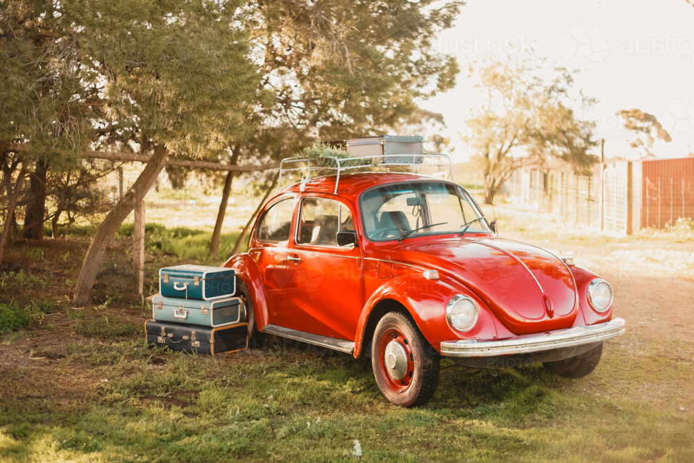 Vibrant red vintage car with antique suitcases - Australian Stock Image