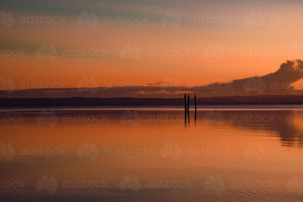Vibrant sunset sky over Tuggerah Lake from Canton Beach on the Central Coast in Toukley, NSW - Australian Stock Image