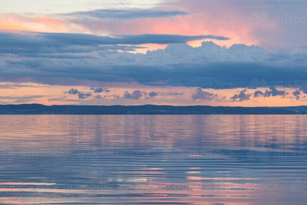 Vibrant sunset sky over Tuggerah Lake from Canton Beach on the Central Coast in Toukley, NSW Austral - Australian Stock Image
