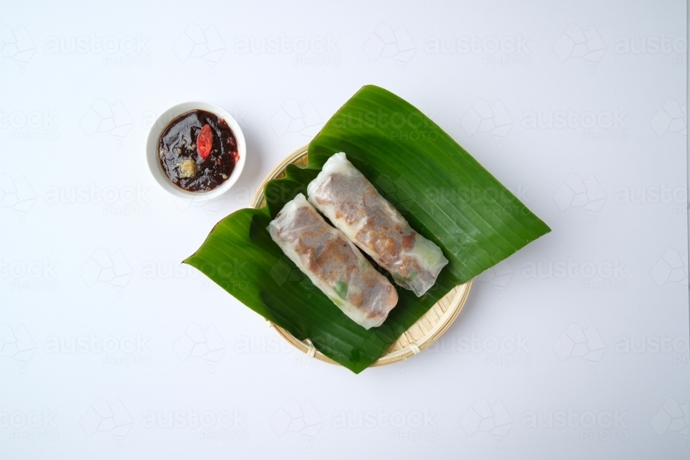 Image of Vietnamese spring rolls on leaf in bamboo bowl with dipping ...