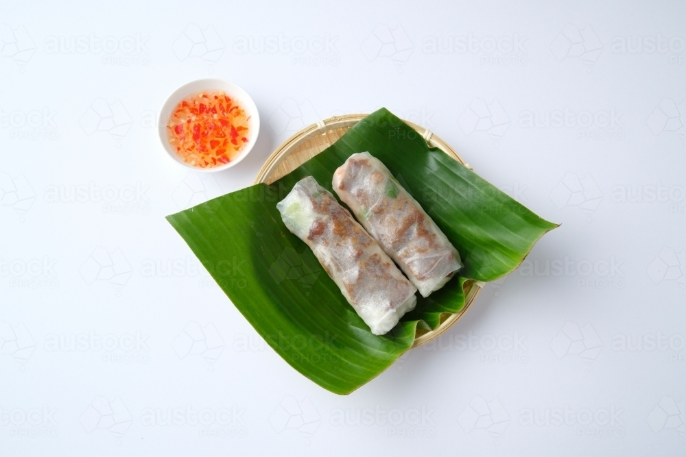 Image of Vietnamese spring rolls on leaf in bamboo bowl with dipping ...
