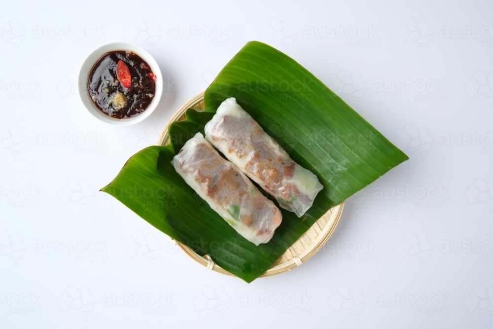 Image of Vietnamese spring rolls on leaf in bamboo bowl with dipping ...