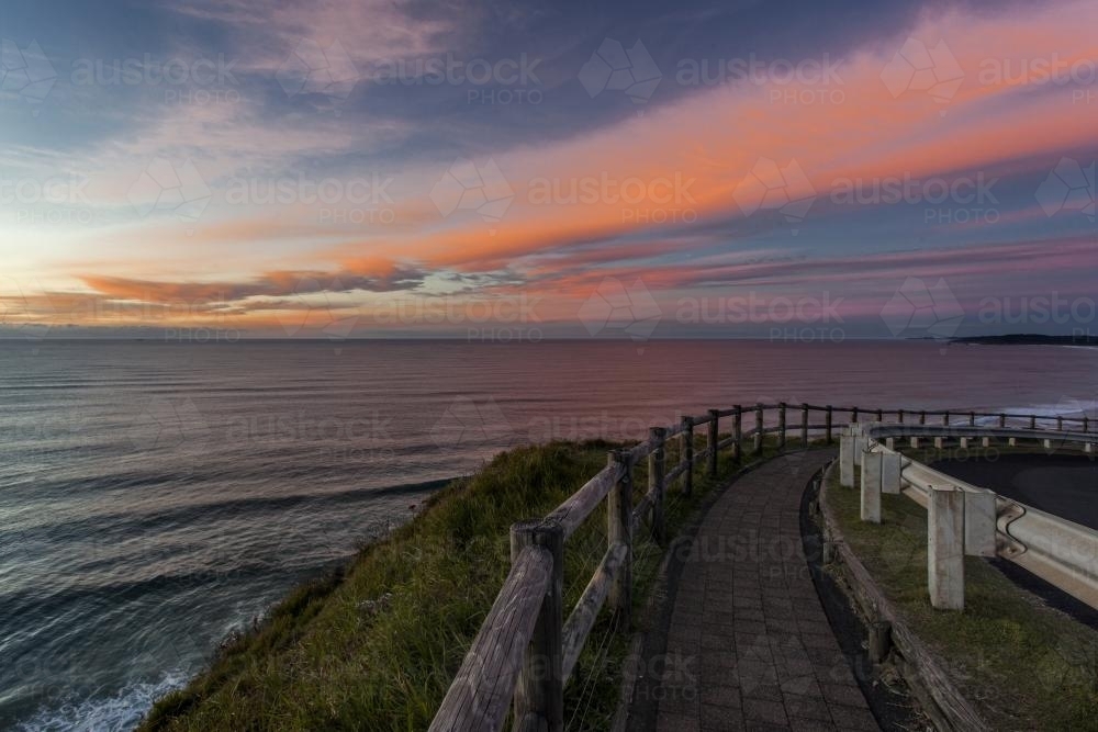 view down a road by the ocean at sunrise - Australian Stock Image