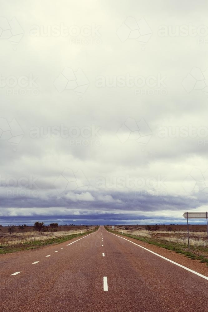 View down a straight flat sealed road in a remote location - Australian Stock Image