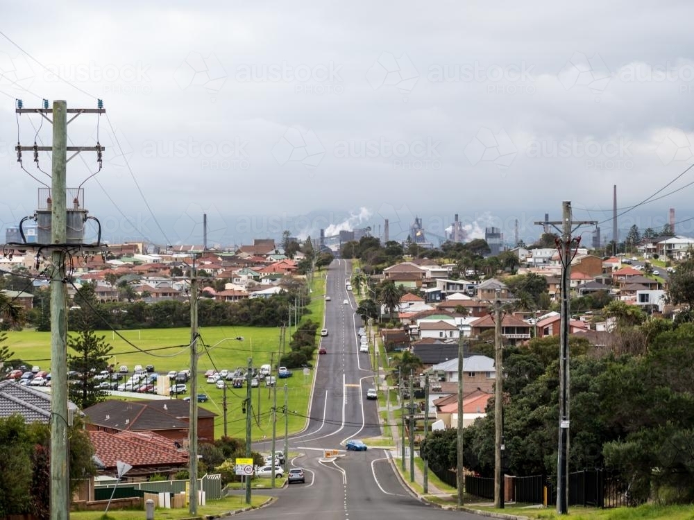 View down a town street towards the Port Kembla steelworks - Australian Stock Image