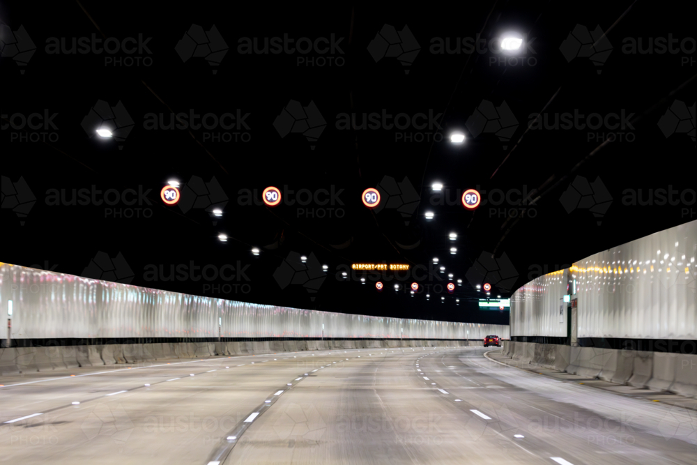 View from a car, Sydney toll road tunnel showing speed signs and four lanes - Australian Stock Image