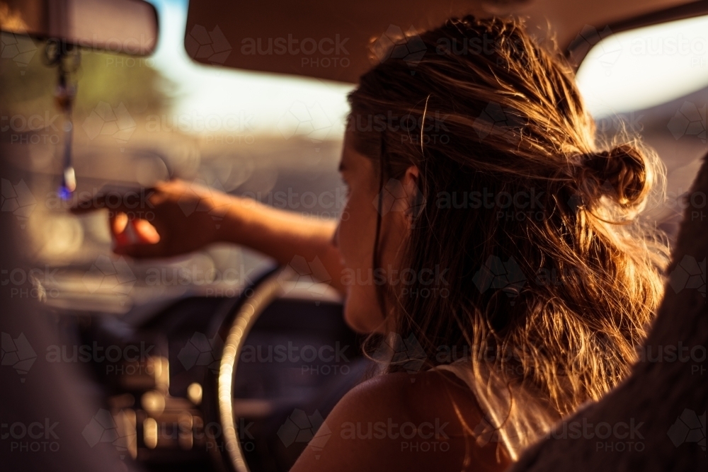 View from back of vehicle of woman driving van in regional area - Australian Stock Image