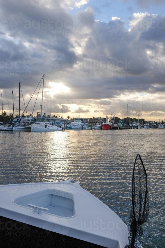 View from boat of sun shining over harbour and distant boats - Australian Stock Image