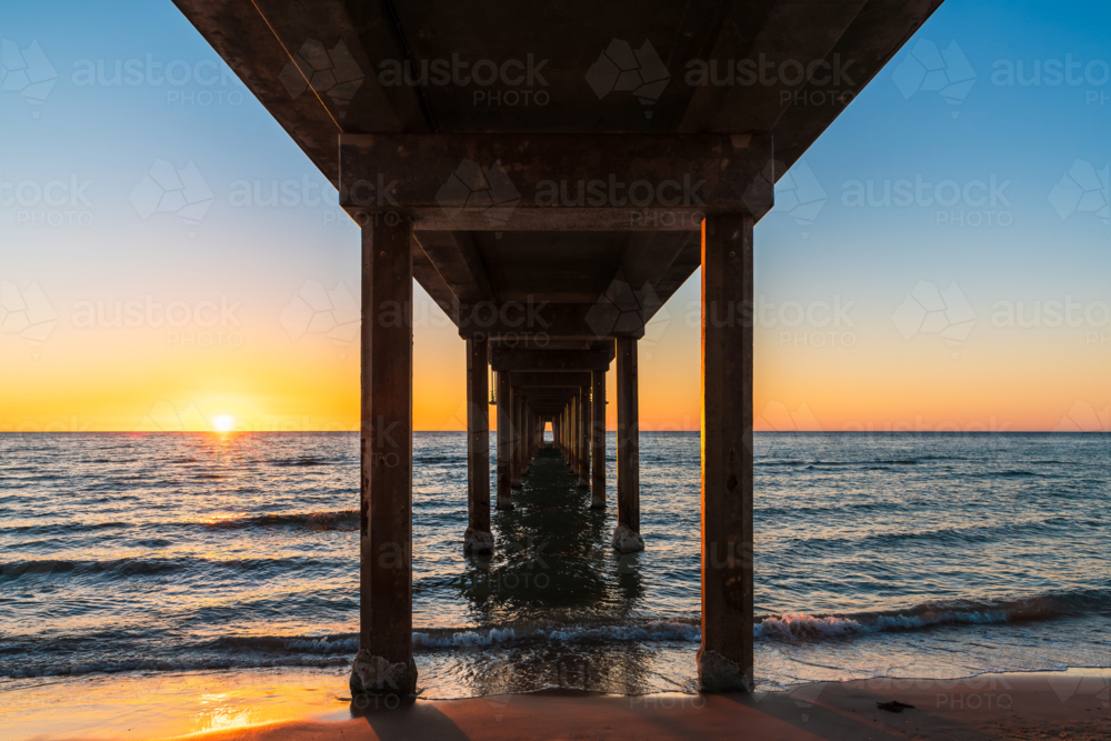 View from down under Brighton Jetty while standing on beach during sunset on summer evening - Australian Stock Image