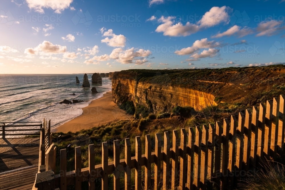 View from fenced lookout of coastal monoliths known as The Twelve Apostles, in beautiful the sunset - Australian Stock Image