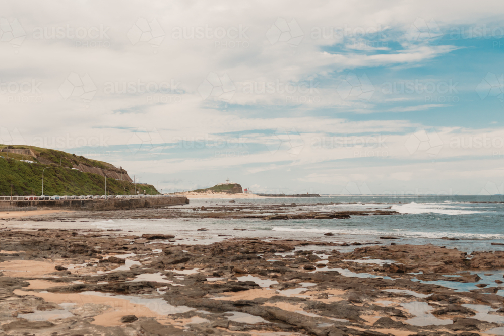 View from Newcastle Ocean Baths looking north towards Nobbys Beach and Nobbys Lighthouse - Australian Stock Image