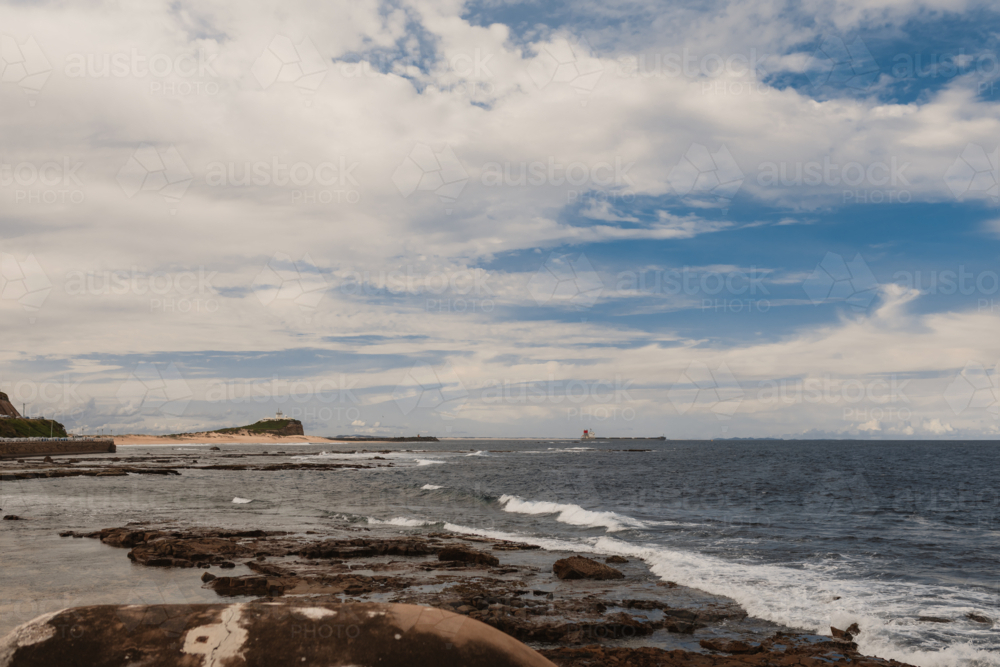View from Newcastle Ocean Baths looking north towards Nobbys Beach and Nobbys Lighthouse - Australian Stock Image