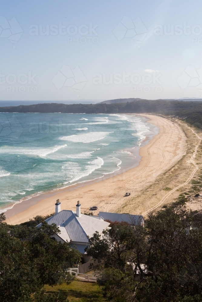 View from Sugar loaf point over lighthouse beach where people are four wheel driving - Australian Stock Image