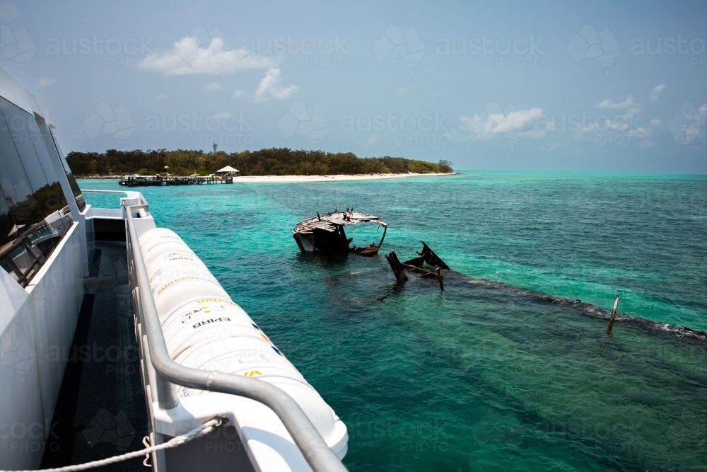 view from the boat approaching Heron Island going past a ship wreck on the reef - Australian Stock Image