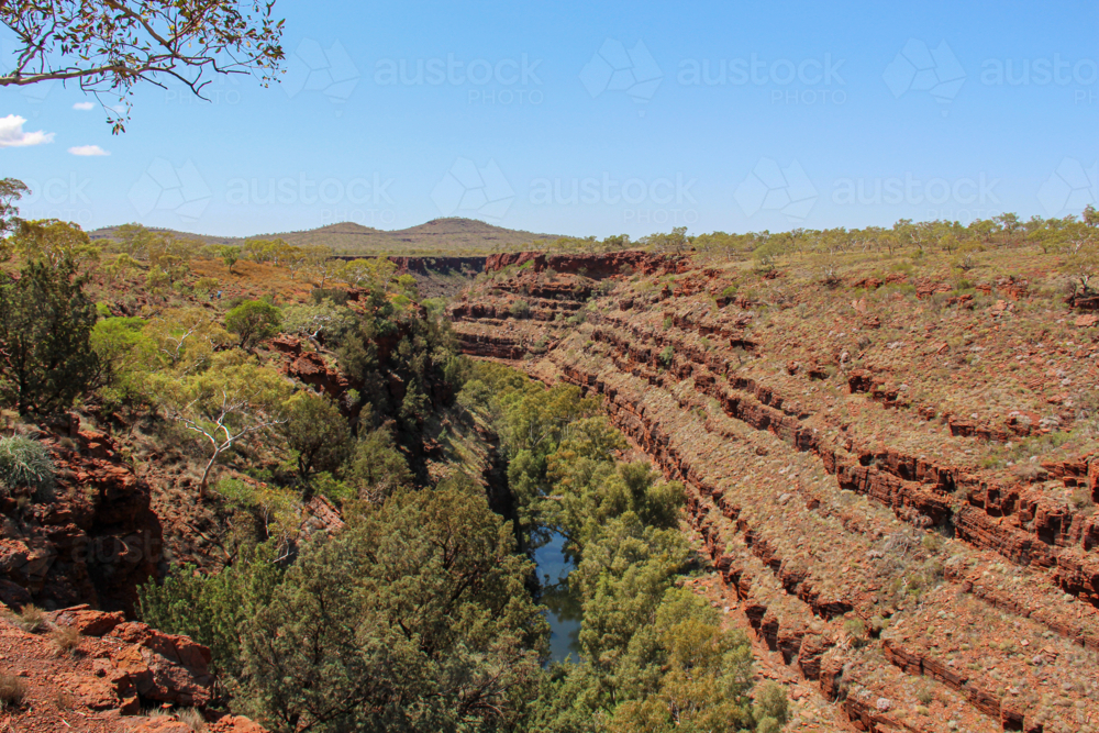 View looking out onto a red rock layered gorge - Australian Stock Image