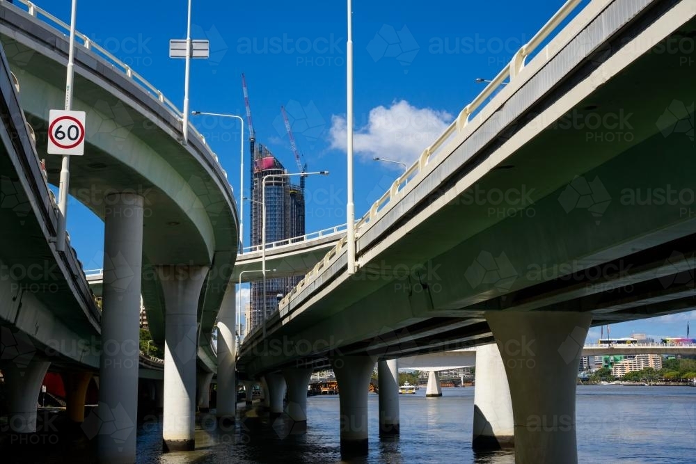 View of a highrise building framed by the Brisbane riverside expressway  bridges and overpasses - Australian Stock Image