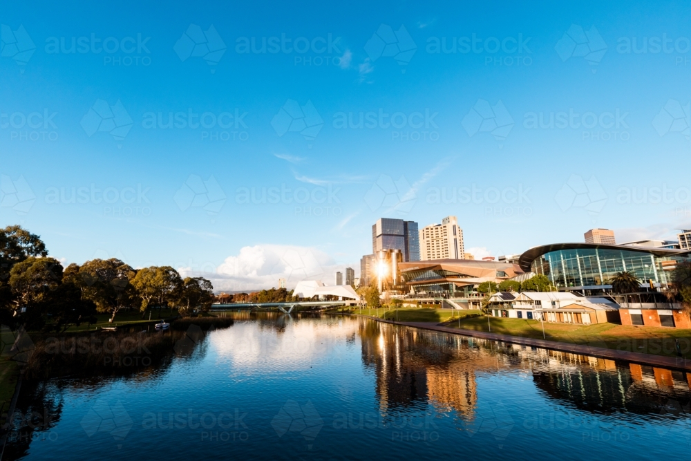 View of Adelaide city across the Torrens River with bright afternoon sunlight reflecting - Australian Stock Image