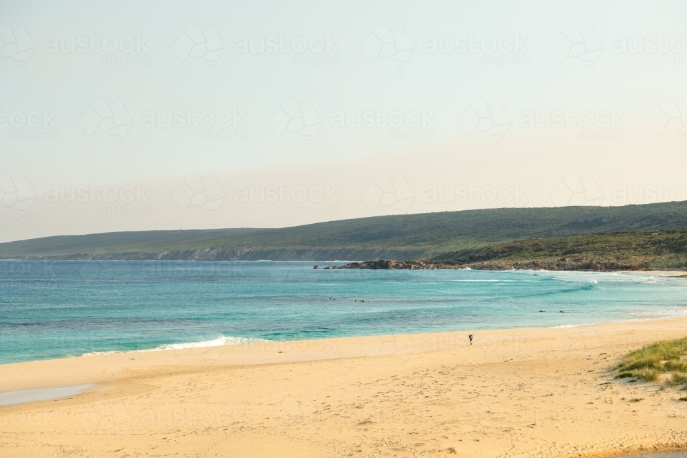 View of beach and ocean of hiker on beach and surfers - Australian Stock Image