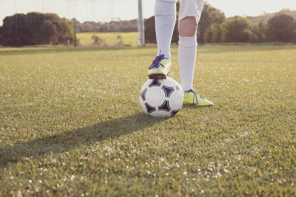 View of boys legs and ball at soccer training - Australian Stock Image