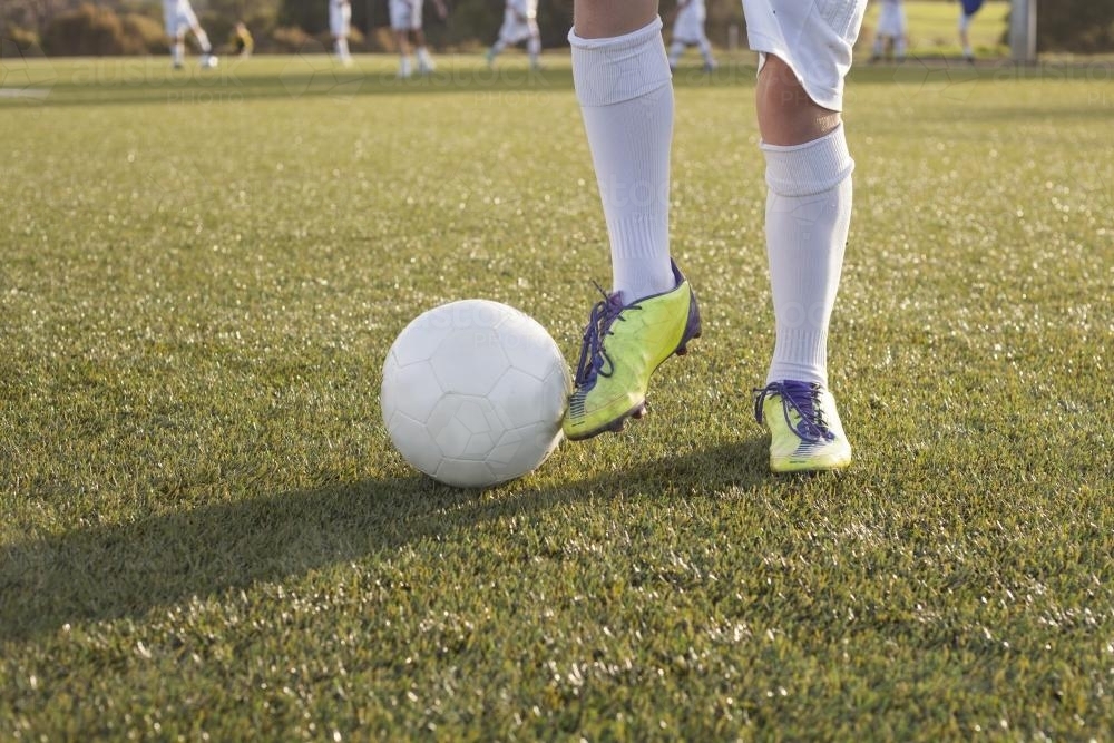 View of boys legs and ball at soccer training - Australian Stock Image