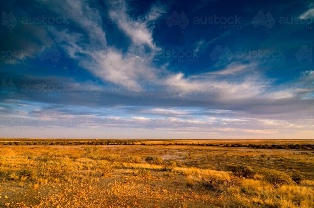 View of desert Channel Country from escarpment with cloud formation - Australian Stock Image
