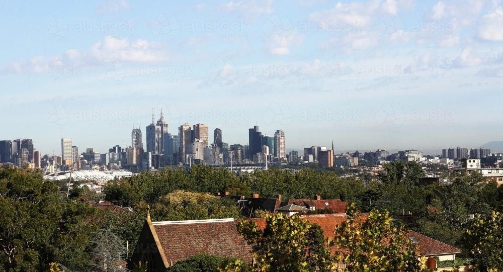 View of high rise buildings on Melbourne skyline over trees - Australian Stock Image