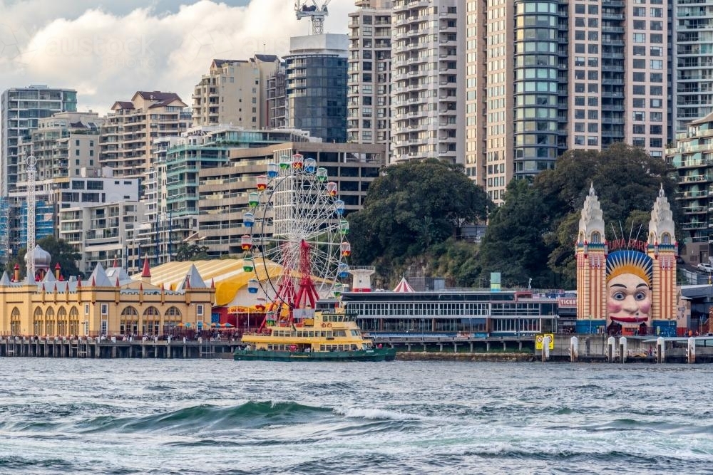 View of Luna Park and city skyscrapers across water - Australian Stock Image