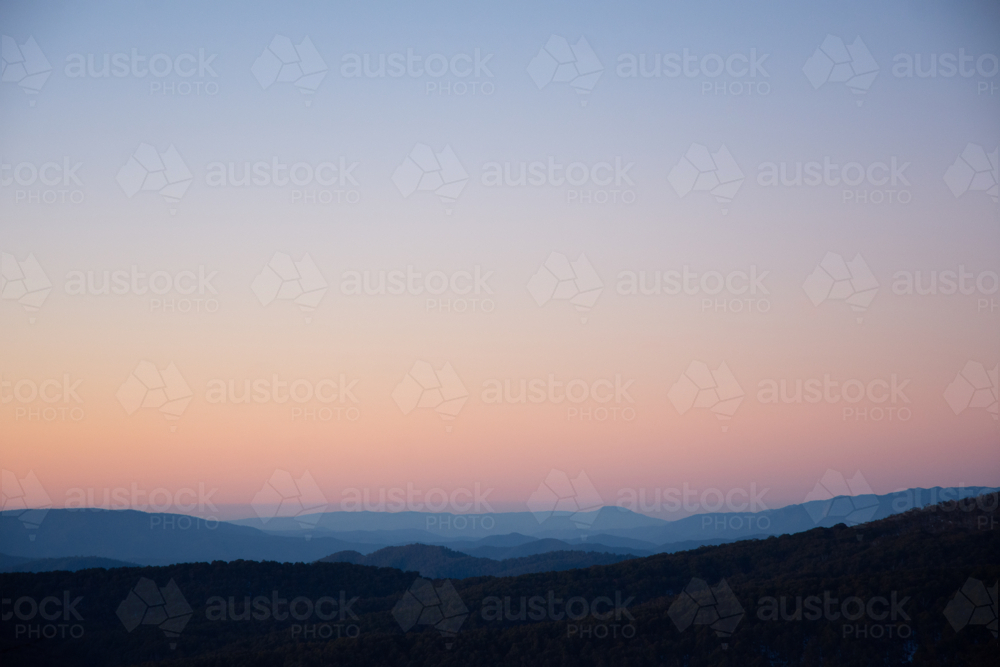 View of mountain range at sunset with coloured sky - Australian Stock Image