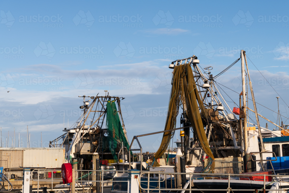 View of nets and equipment on ocean going fishing boats in the harbour - Australian Stock Image