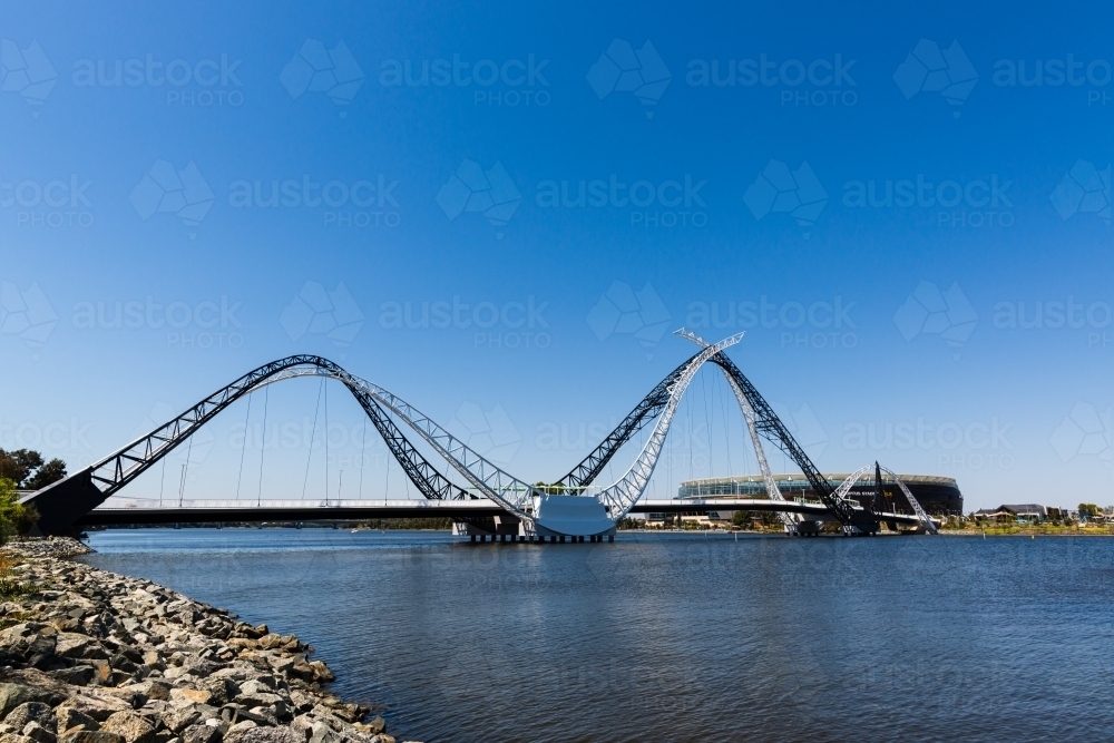 View of the Matagarup Bridge, sports stadium and river with large area of clear blue sky - Australian Stock Image