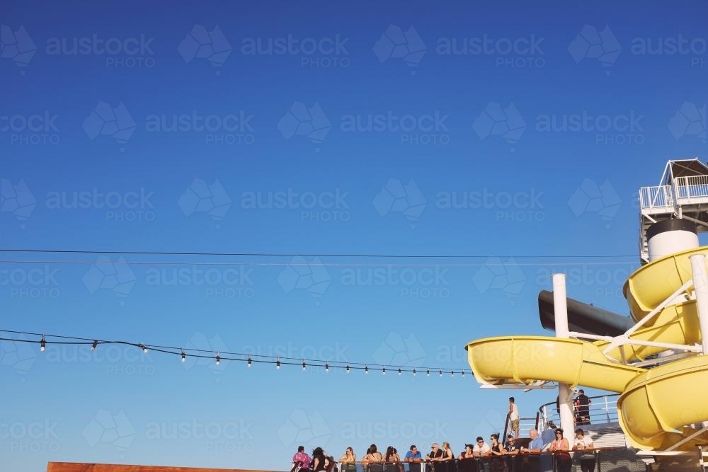 View of water slide, lights and people on the deck of a cruise ship - Australian Stock Image