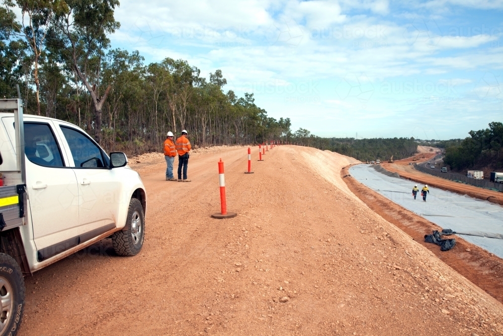 View of workers and heavy machinery on a road construction worksite - Australian Stock Image