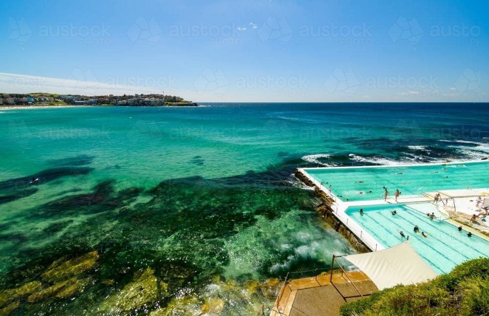 View out to sea and overlooking swimming pool with swimmers - Australian Stock Image