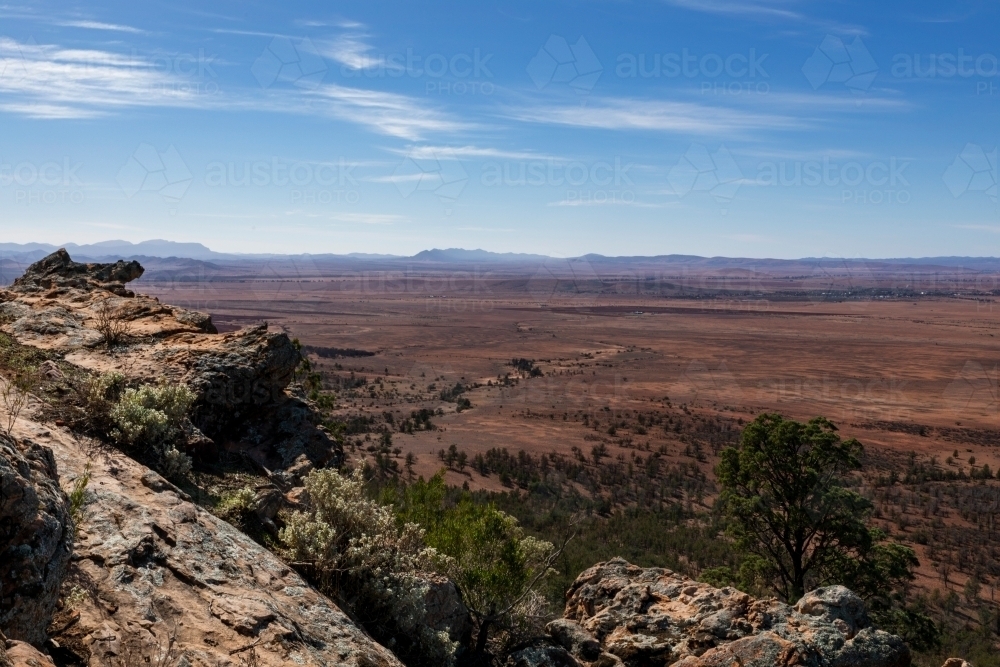 View over arid plains from rocky hill - Australian Stock Image