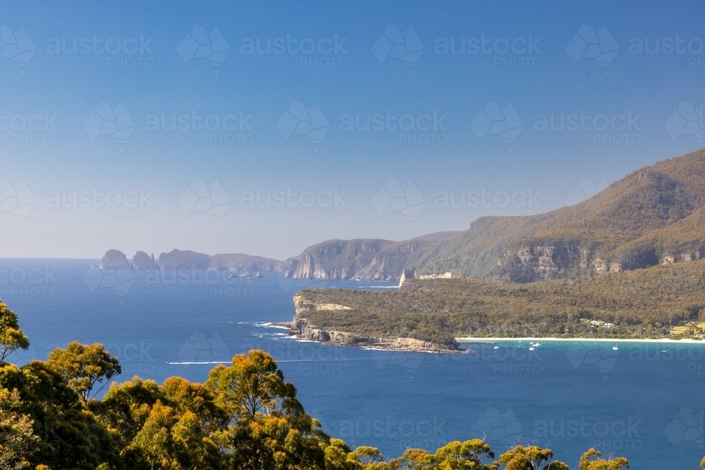 View over Pirates Bay and Tasman Peninsula with sea cliffs, blue water and clear sky - Australian Stock Image