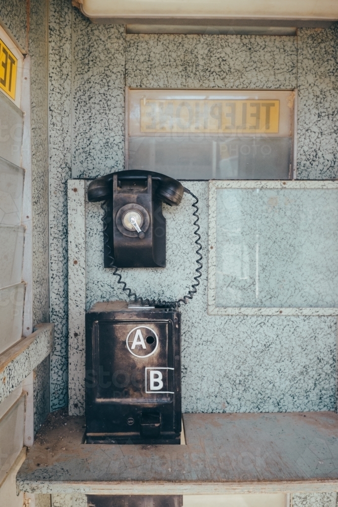 Vintage black telephone inside an old phone box - Australian Stock Image