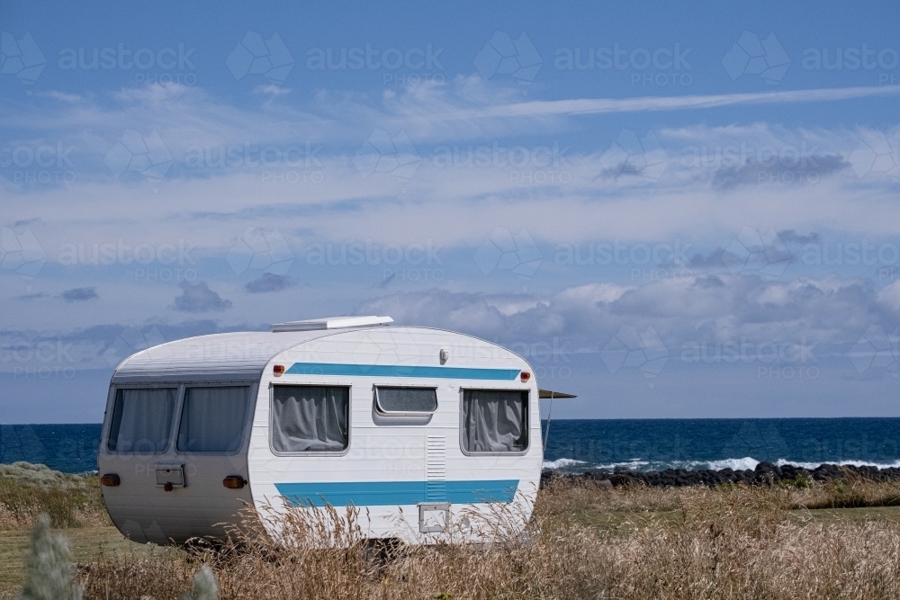 Vintage caravan set up by the ocean. - Australian Stock Image