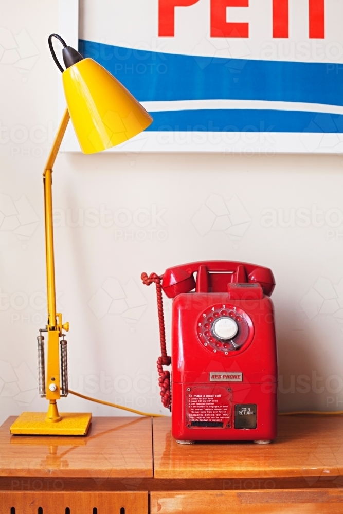 Vintage red payphone with retro yellow lamp - Australian Stock Image