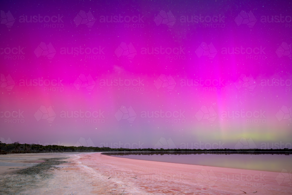 Vivid pink and purple Aurora Australis over the Pink Lake at night. - Australian Stock Image