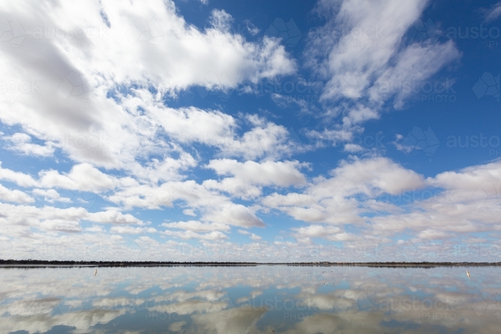 Vivid sky with clouds reflecting in a lake - Australian Stock Image