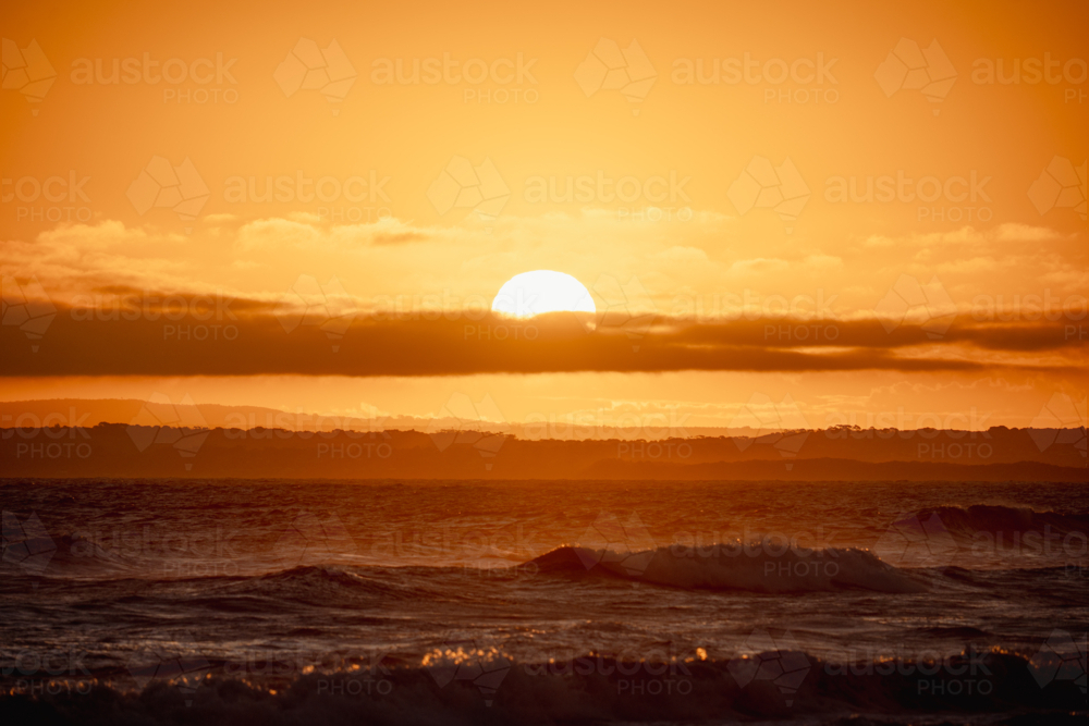 Vivid sunset over ocean with golden reflections - Australian Stock Image