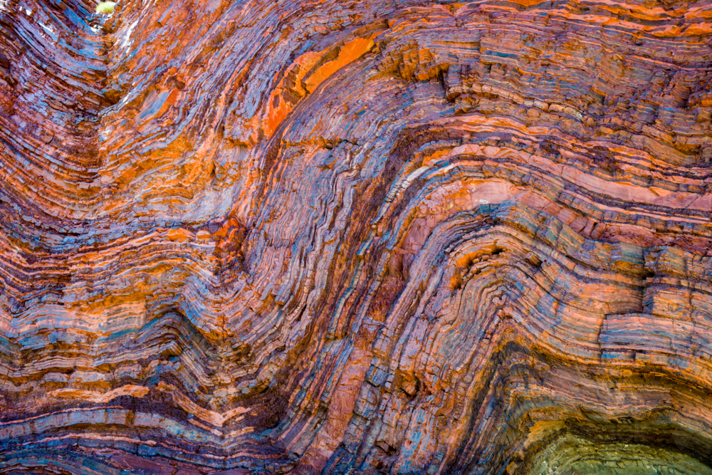 Vividly coloured and contorted rock strata in ancient layered gorge walls - Australian Stock Image
