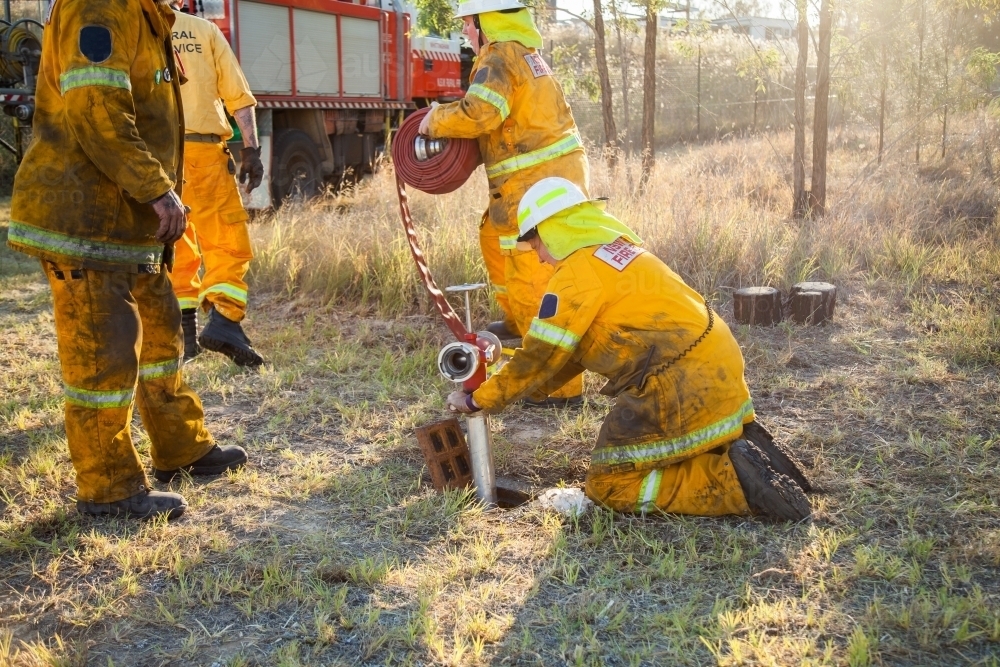 Volunteer firefighters in NSW rural fire brigade attaching fire hydrant and hose - Australian Stock Image