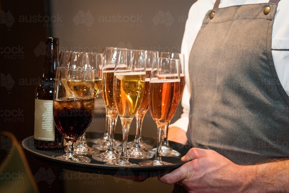 Waiter carrying a tray of drinks - Australian Stock Image