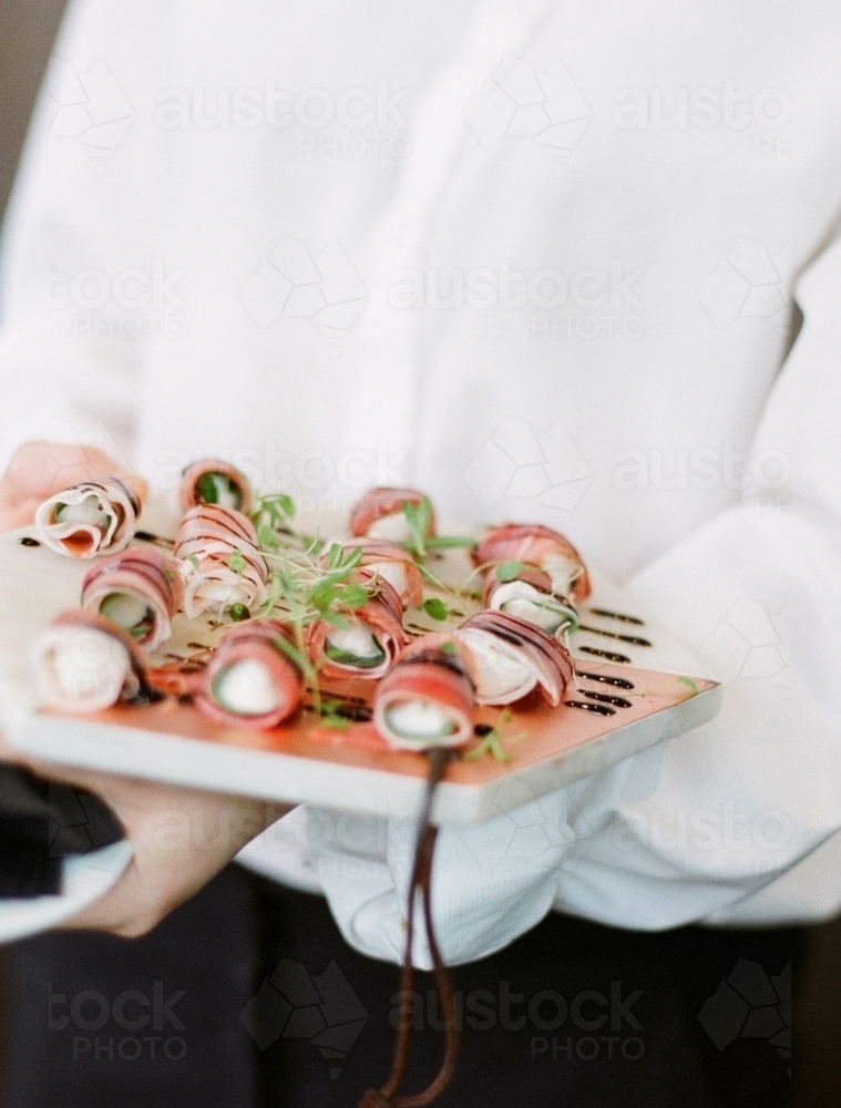 Waiter holding  plate of canapés at a wedding - Australian Stock Image