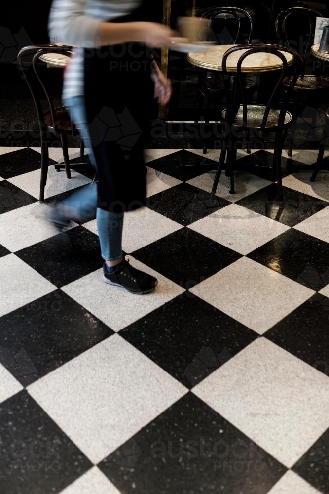 Waitress walking with a glass of coffee - Australian Stock Image